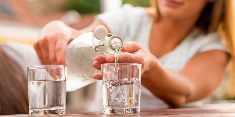 woman pouring water in a glass